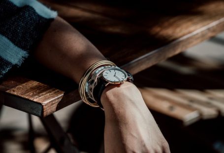 Wooden Jewelry - person wearing analog watch leaning on the table