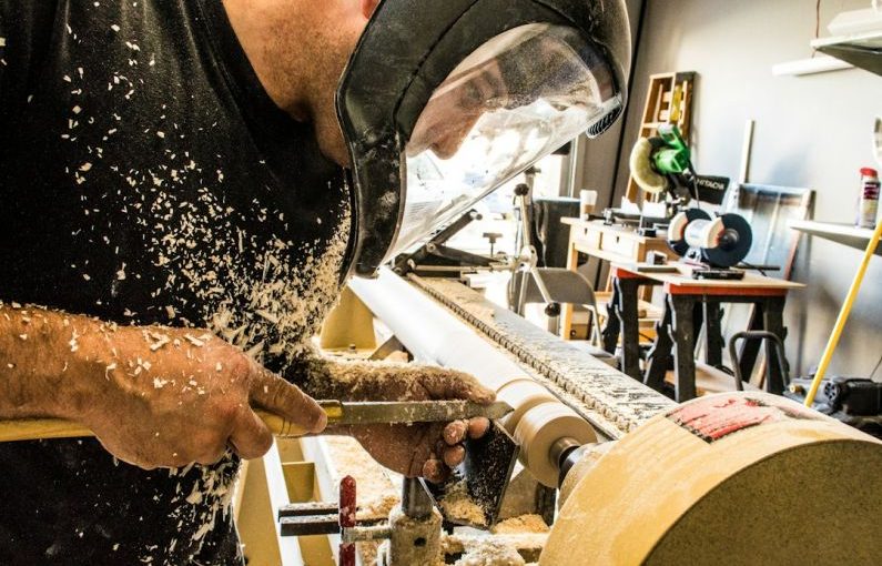 Carving Vises - man wearing welding helmet in front of industrial machine