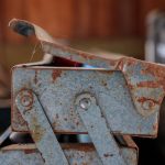 Tool Storage - a rusted metal object sitting on top of a table
