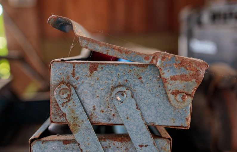 Tool Storage - a rusted metal object sitting on top of a table